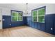Bright dining room featuring stylish wainscoting, a modern chandelier, large windows and wood flooring at 125 Oswego Dr, Louisburg, NC 27549
