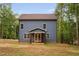 Two-story home features blue siding, light brick porch and double-hung windows surrounded by mature trees at 125 Oswego Dr, Louisburg, NC 27549
