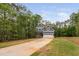 Charming two-story home featuring a blue exterior and a long driveway surrounded by lush trees at 125 Oswego Dr, Louisburg, NC 27549