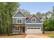 Charming two-story home featuring a blue exterior, a two-car garage and a well manicured front yard at 125 Oswego Dr, Louisburg, NC 27549