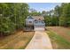 Beautiful two-story home with blue siding, a long driveway, and lush surrounding trees at 125 Oswego Dr, Louisburg, NC 27549
