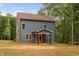 Two-story home features blue siding, light brick porch and double-hung windows surrounded by mature trees at 125 Oswego Dr, Louisburg, NC 27549