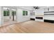Bright living room with modern fireplace, light wood floors, large windows and french doors to a patio at 125 Oswego Dr, Louisburg, NC 27549
