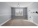 Carpeted bedroom featuring a geometric hanging light fixture, and a large window at 130 Virginia Water Dr, Rolesville, NC 27571