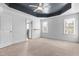 Bedroom features carpet, tray ceiling, ceiling fan, and two large windows at 130 Virginia Water Dr, Rolesville, NC 27571