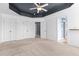 Spacious bedroom featuring a tray ceiling, ceiling fan, three closets, and two doors at 130 Virginia Water Dr, Rolesville, NC 27571