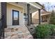 Inviting front porch with stone steps, dark wood columns and black metal railing for a touch of elegance at 130 Virginia Water Dr, Rolesville, NC 27571
