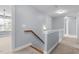 Upstairs hallway with carpeted floors, wood handrail and sconce lighting at 130 Virginia Water Dr, Rolesville, NC 27571