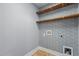 Laundry room with geometric wallpaper and floating wood shelves at 130 Virginia Water Dr, Rolesville, NC 27571