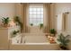 Tranquil bathroom featuring a soaking tub, natural light, neutral tones, and decorative plants at 131 Hawick Ct, Zebulon, NC 27597
