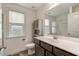 Bathroom featuring a granite vanity, framed mirror, framed window and tub with glass doors at 131 Hawick Ct, Zebulon, NC 27597