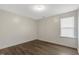Neutral bedroom with wood-look flooring, a large window, and a ceiling light at 131 Hawick Ct, Zebulon, NC 27597