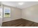 Bright bedroom with wood-look flooring, a large window, and a ceiling light at 131 Hawick Ct, Zebulon, NC 27597