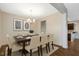 Bright dining room with modern chandelier, neutral color palette, and seating for eight at 131 Hawick Ct, Zebulon, NC 27597
