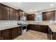 Well-lit kitchen featuring dark wood cabinets, granite countertops, and stainless steel appliances at 131 Hawick Ct, Zebulon, NC 27597