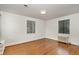 A simple bedroom with hardwood floors, two windows, and natural light at 1541 Caswell St, Raleigh, NC 27608