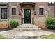 Inviting front entrance with stone steps, decorative sconces, and black framed glass door at 1541 Caswell St, Raleigh, NC 27608