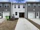 View of the rear of the townhome featuring a two-car garage and a concrete driveway at 1945 Plott Balsam Dr, Wendell, NC 27591