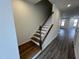 Staircase featuring wood steps, white risers, and a dark wood handrail at 1945 Plott Balsam Dr, Wendell, NC 27591