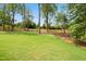 Large backyard featuring a lush green lawn, mature trees, and a wood fence at 217 Dublin Rd, Raleigh, NC 27609