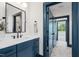 Stylish bathroom features a navy vanity, a black framed mirror, and marble floors at 217 Dublin Rd, Raleigh, NC 27609