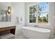Bathroom featuring a soaking tub near a window, vanity and a sleek, modern design at 217 Dublin Rd, Raleigh, NC 27609