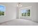 A bright bedroom with carpeted floor, windows providing ample natural light, and modern chandelier at 217 Dublin Rd, Raleigh, NC 27609