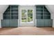 Bonus room showcasing built-in shelving on either side of a window, with hardwood flooring and natural light at 217 Dublin Rd, Raleigh, NC 27609