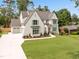 Spacious home featuring a well-manicured lawn, lush landscaping, and an attached three-car garage at 217 Dublin Rd, Raleigh, NC 27609
