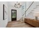 Bright foyer featuring hardwood floors, staircase, and a decorative chandelier, creating a welcoming ambiance at 217 Dublin Rd, Raleigh, NC 27609