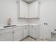 White laundry room with ample cabinet space, sleek countertops, and modern fixtures at 217 Dublin Rd, Raleigh, NC 27609