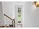 Bright stairwell featuring white walls, wood steps, and a large window for natural light at 217 Dublin Rd, Raleigh, NC 27609