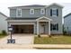Two-story home featuring an attached garage, gray siding, black shutters, and a well-maintained front lawn at 2258 Cherry Creek Rd, Haw River, NC 27258