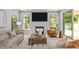 Bright living room featuring a fireplace, large windows, and comfortable seating at 248 Speight Branch Rd, Cary, NC 27518