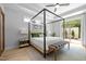 A view of a well-lit main bedroom featuring a canopy bed, ceiling fan and access to the backyard at 248 Speight Branch Rd, Cary, NC 27518