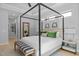 The main bedroom includes a canopy bed, bench, ensuite bathroom access, and decor at 248 Speight Branch Rd, Cary, NC 27518