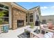 Outdoor patio area featuring a stone fireplace, grill, and comfortable seating at 248 Speight Branch Rd, Cary, NC 27518