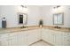 Bathroom with granite countertops, white cabinets, dual sinks, and framed mirrors at 4001 Falls River Ave, Raleigh, NC 27614