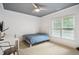 Cozy bedroom features a ceiling fan, carpet, natural light, and a desk area at 4001 Falls River Ave, Raleigh, NC 27614