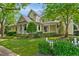 Charming yellow home with inviting front porch, lush landscaping, and a classic white picket fence at 4001 Falls River Ave, Raleigh, NC 27614