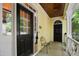 Inviting front porch with black door, yellow siding, wooden ceiling, and decorative flower chair at 4001 Falls River Ave, Raleigh, NC 27614