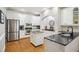 Bright kitchen with white cabinets, black countertops, stainless steel appliances, and a brick alcove at 4001 Falls River Ave, Raleigh, NC 27614