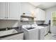 Well-organized laundry room with modern washer and dryer, sleek countertops and ample cabinet storage at 4001 Falls River Ave, Raleigh, NC 27614