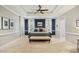 Spacious main bedroom features a tray ceiling, fan, carpet, and a seating bench at the foot of the bed at 4001 Falls River Ave, Raleigh, NC 27614