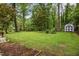 Lush green backyard with a storage shed and mature trees at 402 Forest Rd, Oxford, NC 27565