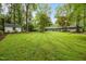 Expansive backyard with lush lawn, mature trees, and a storage shed provides a serene outdoor space at 402 Forest Rd, Oxford, NC 27565