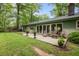 Outdoor patio features flagstone tiles, seating, potted plants, and access to a lush, green backyard at 402 Forest Rd, Oxford, NC 27565