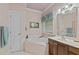 Well-lit bathroom featuring corner bathtub, vanity, and pink wallpaper at 414 Bakewell Ct, Wake Forest, NC 27587