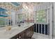 Well-lit bathroom featuring a double sink vanity, floral wallpaper, and a large mirror at 414 Bakewell Ct, Wake Forest, NC 27587