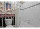 Bathroom with white-tiled shower-tub featuring floral wallpaper and black and white tile accent at 414 Bakewell Ct, Wake Forest, NC 27587